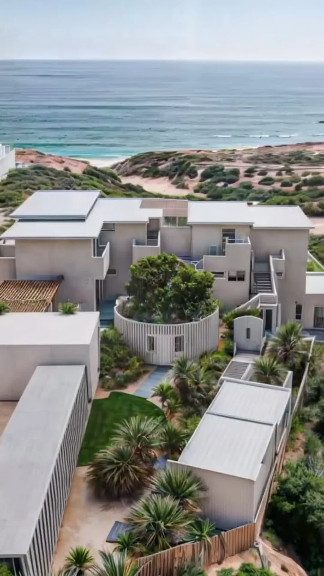 Casa Blanca from the air: white volumes stepping down the dunes to the Sea of Cortez.